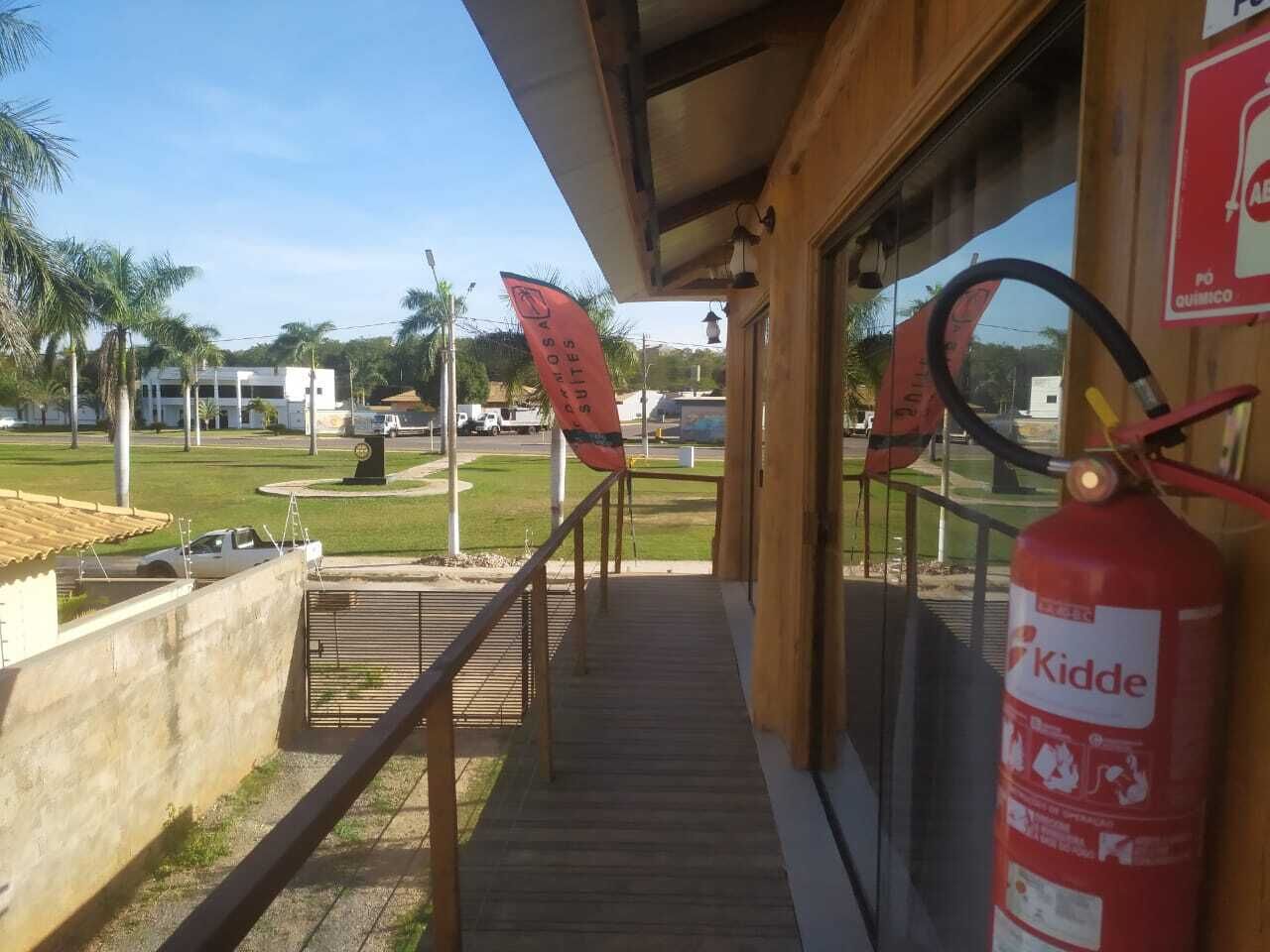 Ein Hotel Eingang mit einer Holzdielenveranda, einem Feuerlöscher und einem Schild mit dem Schriftzug 'Kidde' an der Wand.