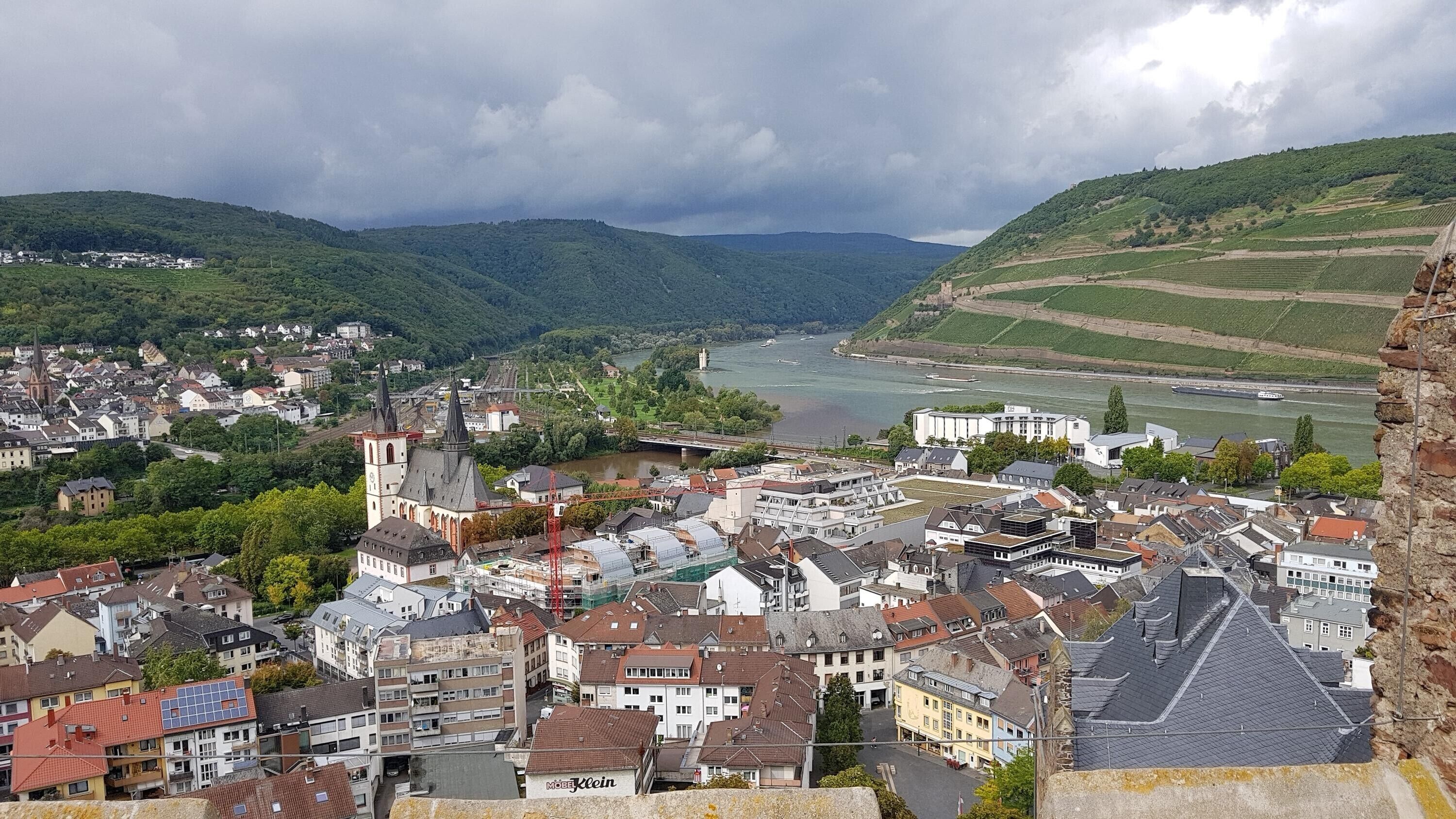 Eine Stadt mit einem Fluss, einer Kirche und einem schlossartigen Gebäude.