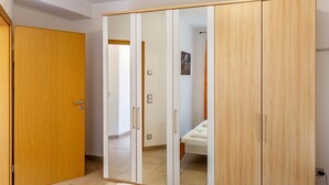 A room with a wardrobe, a bed, and a door leading to another room. - Holiday Apartment "Im Bubenstück" with Wi-Fi (Bingen)