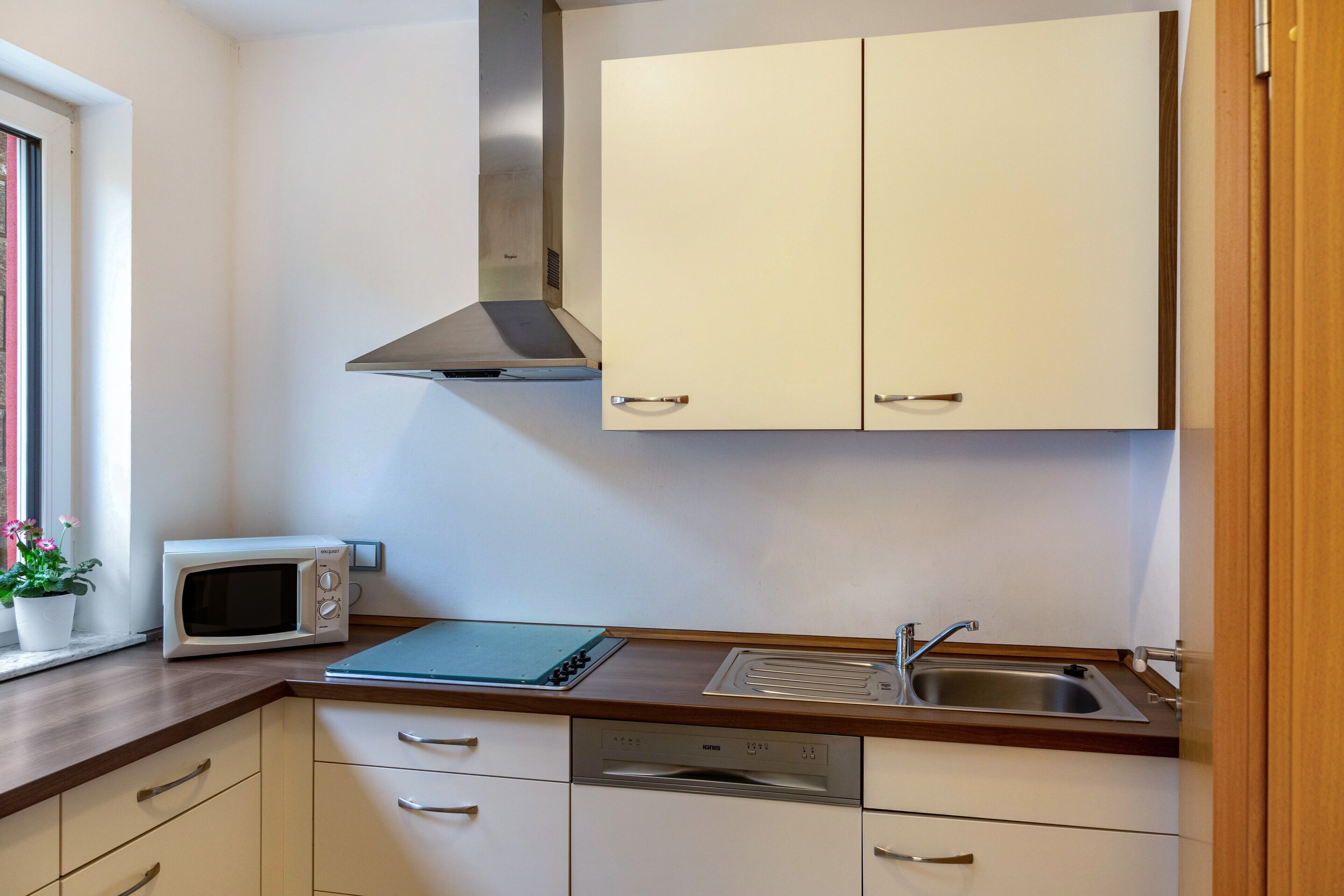 A compact kitchen with a microwave, a sink, and a dishwasher.