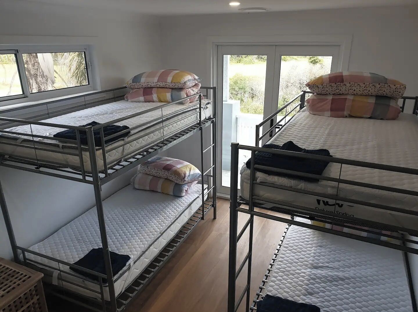 Un dormitorio con literas, una ventana y una puerta que da al exterior.