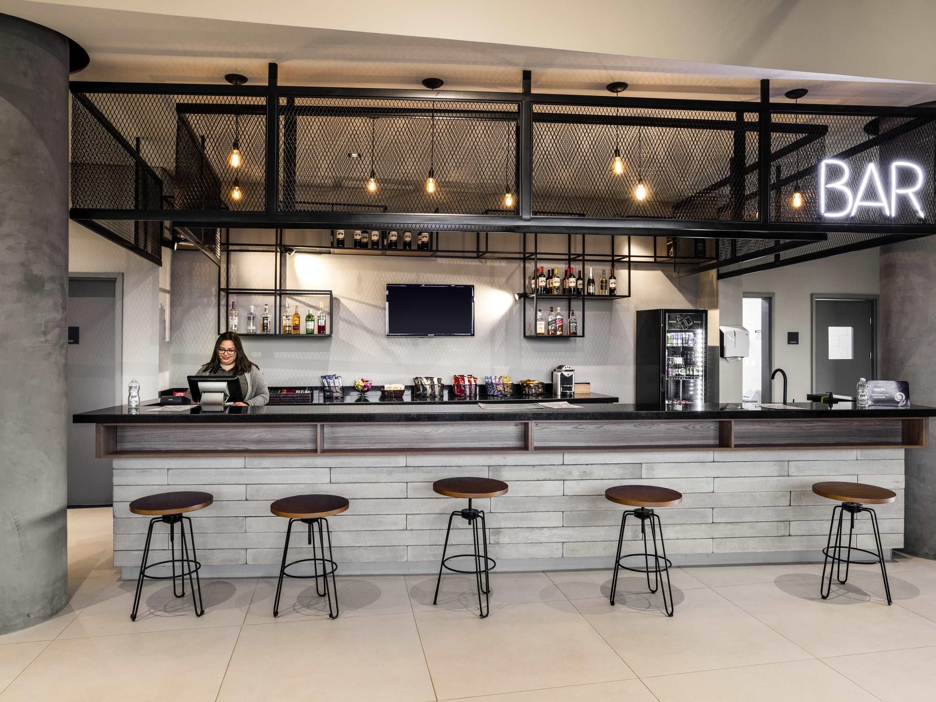 A modern bar area with a counter, stools, and a 'BAR' sign.