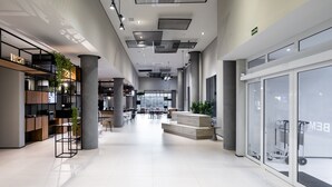 A spacious, modern lobby with high ceilings, a central seating area, and a glass storefront. - Ibis Botucatu (Botucatu)