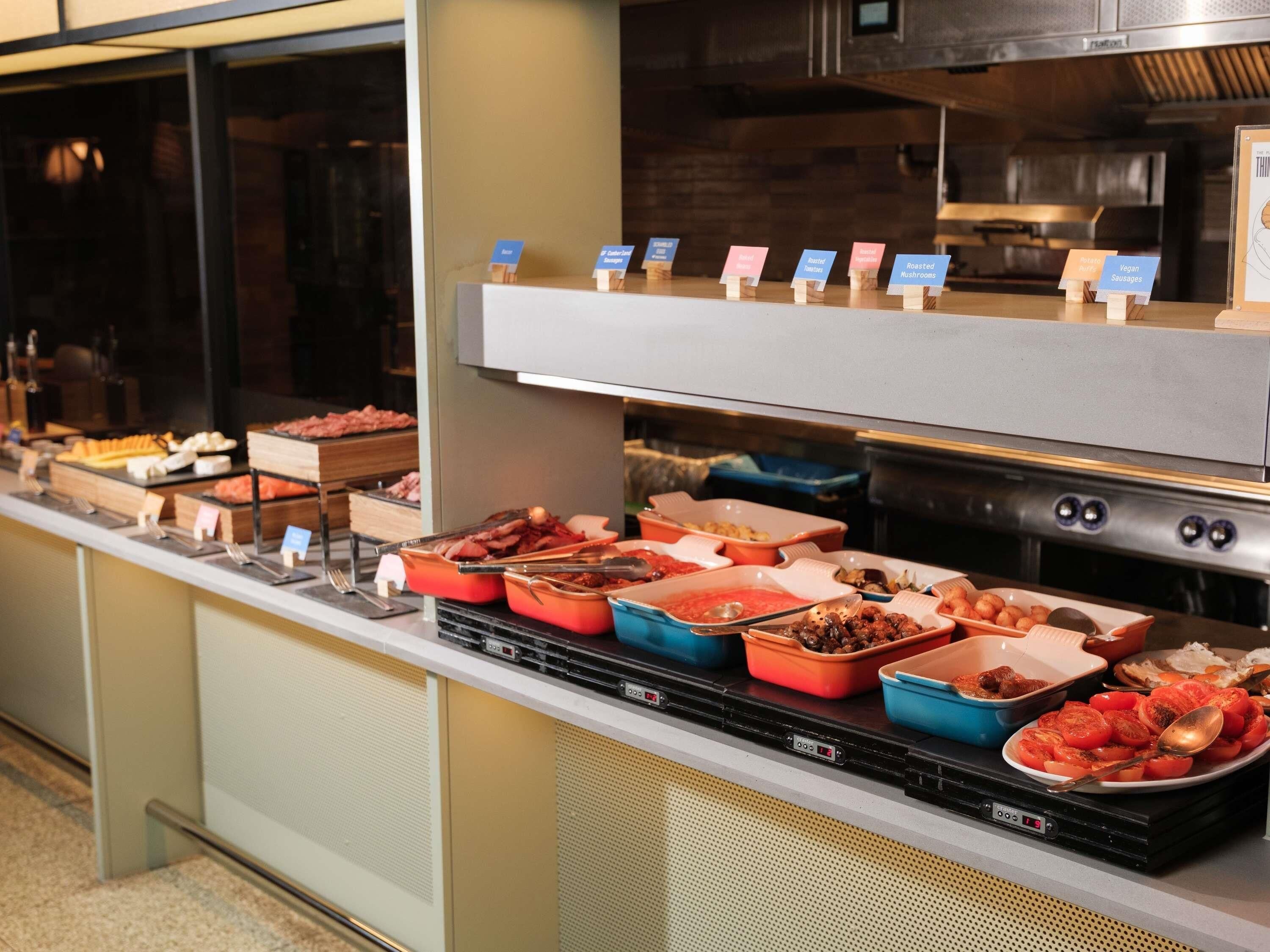 A buffet with various food items and labeled serving dishes.