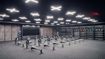 A gym with rowing machines and weight racks.