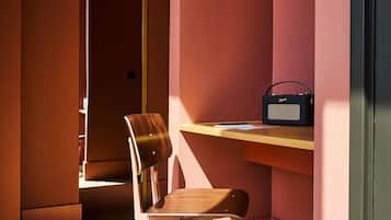 A room with a wooden chair, a desk, and a radio.