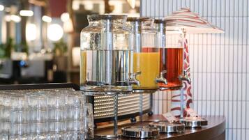 A bar area with multiple drink dispensers and a stack of glasses.
