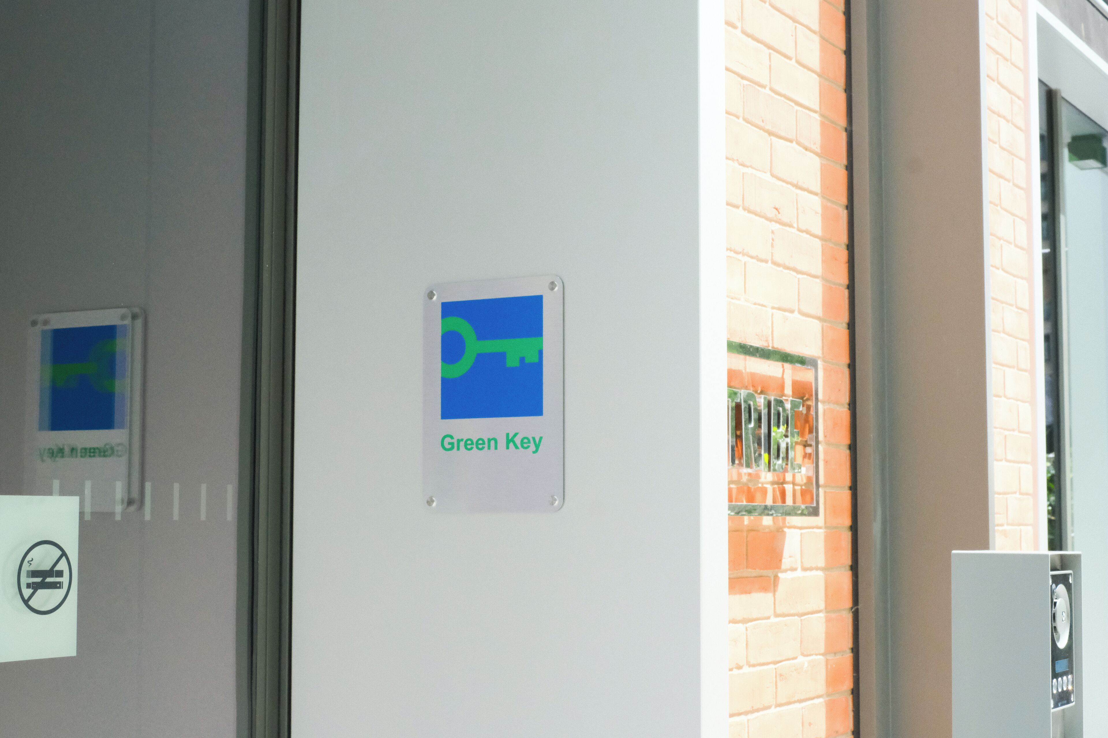Una puerta con un cartel que dice "Green Key" y un letrero de prohibido fumar.