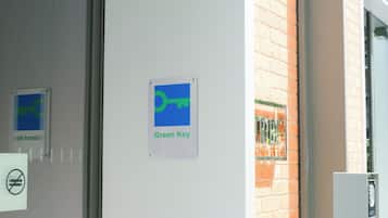 En dörr med en skylt som visar texten ”Green Key” och en skylt som förbjuder rökning.