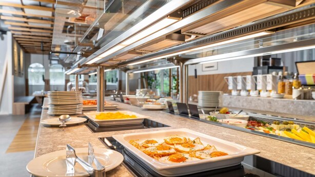 Un buffet proposant une variété de plats, d’assiettes et de couverts.