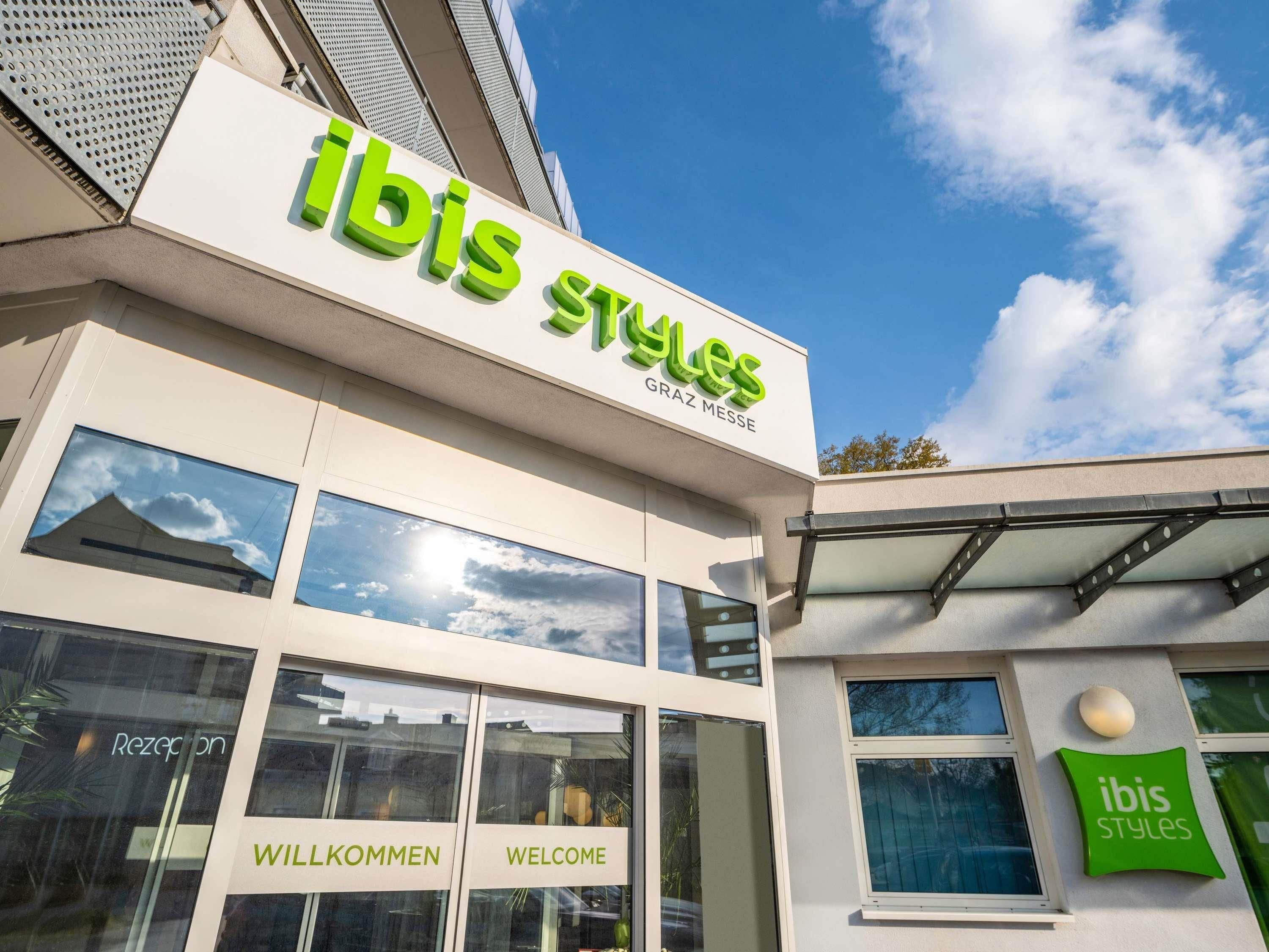 Un edificio con un cartel que dice 'ibis Styles' y 'Graz Messe', indicando una ubicación.