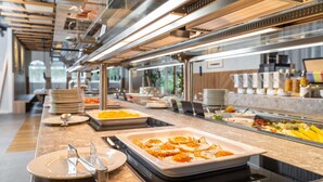 Un buffet proposant une variété de plats, d’assiettes et de couverts.