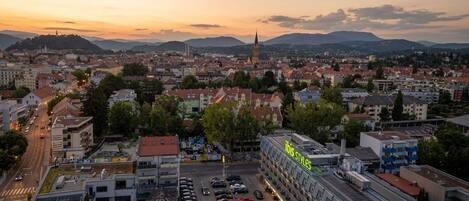 Un paisaje urbano con un edificio destacado identificado como 'ibis styles', que presenta un diseño moderno con paneles solares.