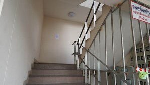A staircase with metal railings and a sign in a foreign language. - RoomQuest Tha Sala (Chiang Mai)