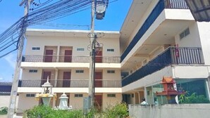 A multi-story building with balconies, a water feature, and a clear sky. - RoomQuest Tha Sala (Chiang Mai)