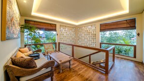 Ein geräumiger Balkon mit Holzboden, einer Holzbank und einem Tisch.