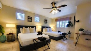 A hotel room with two beds, a ceiling fan, and a small desk with a plant. - Zland is your destination Vacation (San Juan)