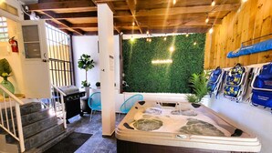 A hot tub in a room with a wooden ceiling, a green wall, and a staircase. - Zland is your destination Vacation (San Juan)