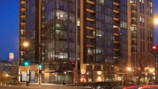 A multi-story hotel with a modern glass facade, multiple balconies, and a ground-level entrance. - Luxury Cherry Blossom Suite 15 min from Downtown (Washington)