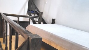 A wooden floor, a metal railing, and a white bed in a room. - Cute Compact One BHK Apartment Near Center ! 10 mins walk (Cluj-Napoca)