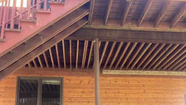 A wooden cabin with a red staircase, a door, and two windows. - Valdez Robe River Front Property (Valdez)