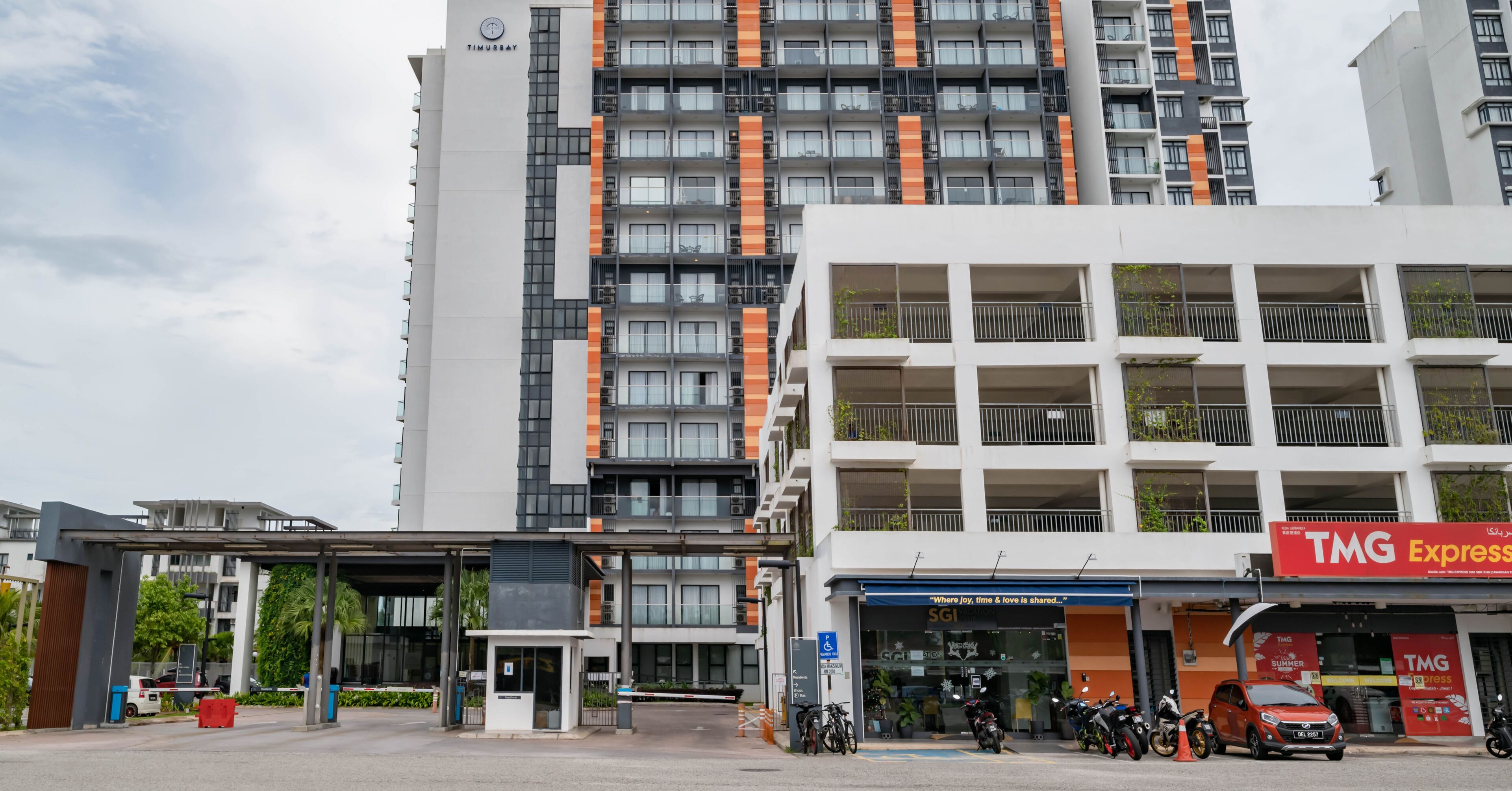 Un bâtiment moderne à plusieurs étages, doté d’une entrée couverte et d’une enseigne bien visible indiquant le nom de l’entreprise, « SGI ».