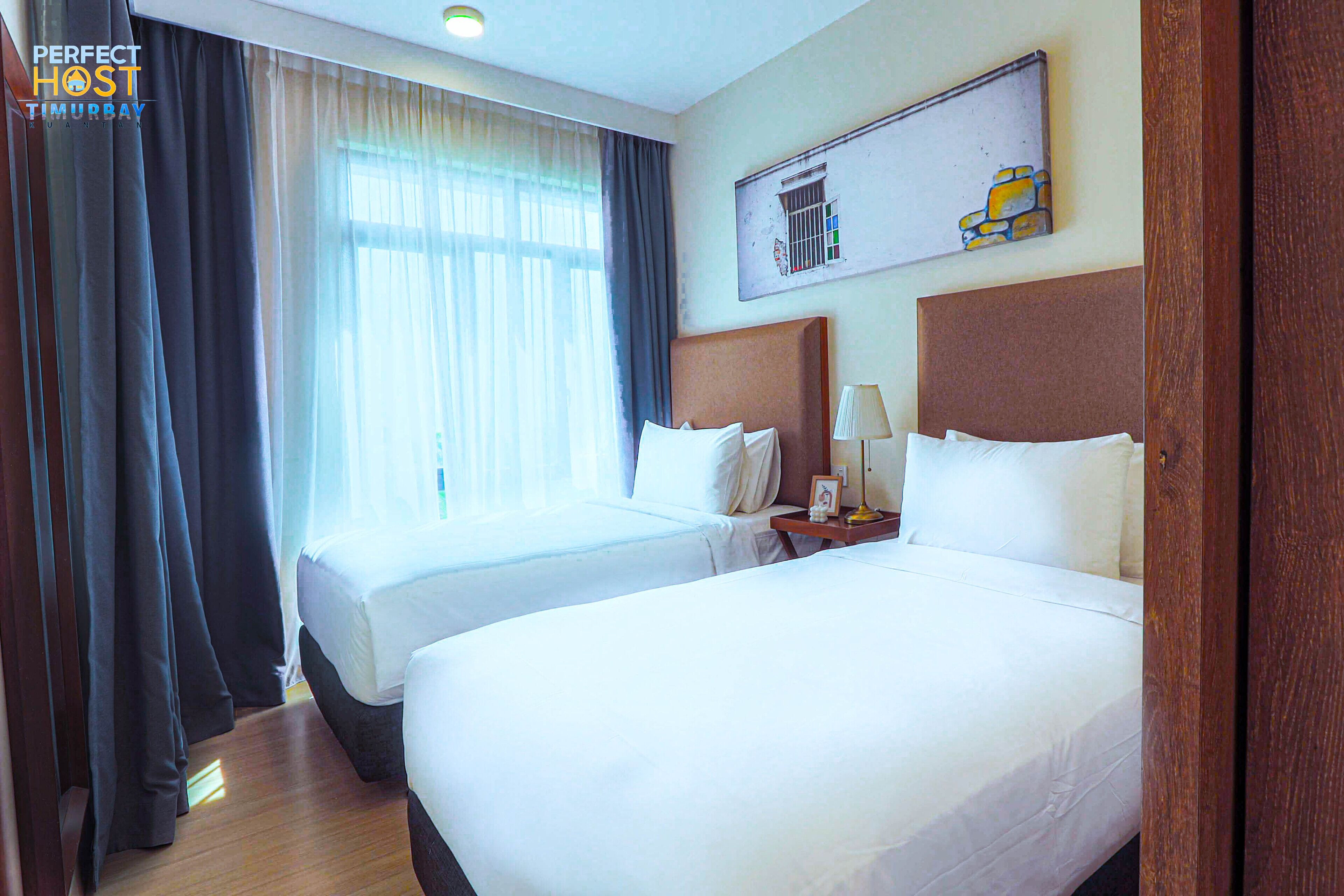 A hotel room with two beds, a nightstand with a lamp, and a painting on the wall.