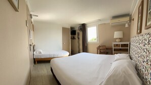 A hotel room with two single beds, a desk, a chair, a wardrobe, and a window with curtains. - Le Sud Hotel (Mauguio)