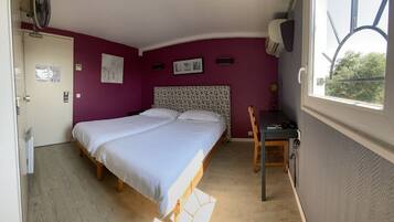 A room with a bed, a desk, a chair, a window, and a door.