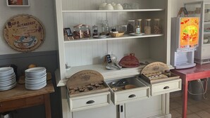 A breakfast bar with a coffee machine, jars of condiments, and a sign for 'Bed & Breakfast'. - Le Sud Hotel (Mauguio)