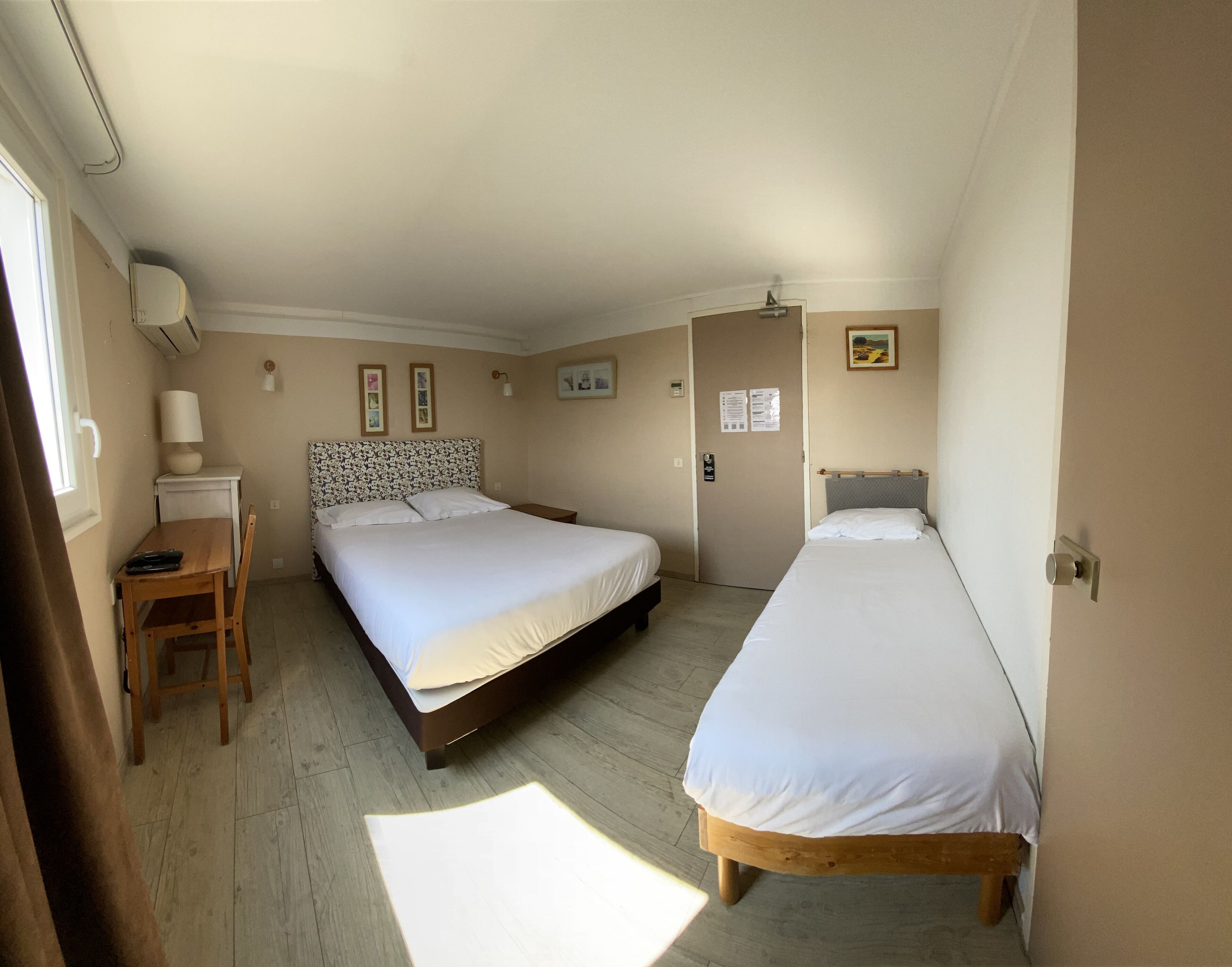 Ein Schlafzimmer mit zwei Betten, einem Schreibtisch und einem Stuhl.