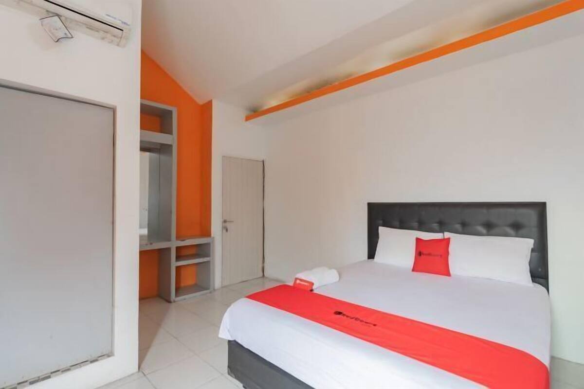 Une chambre d’hôtel avec un lit, une armoire et une porte.