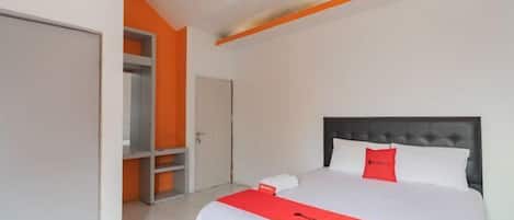 A hotel room with a bed, a wardrobe, and a door.