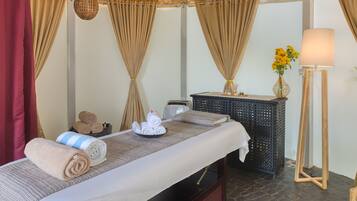 Relax in comfort with a neatly made bed, massage table, and soothing ambiance.