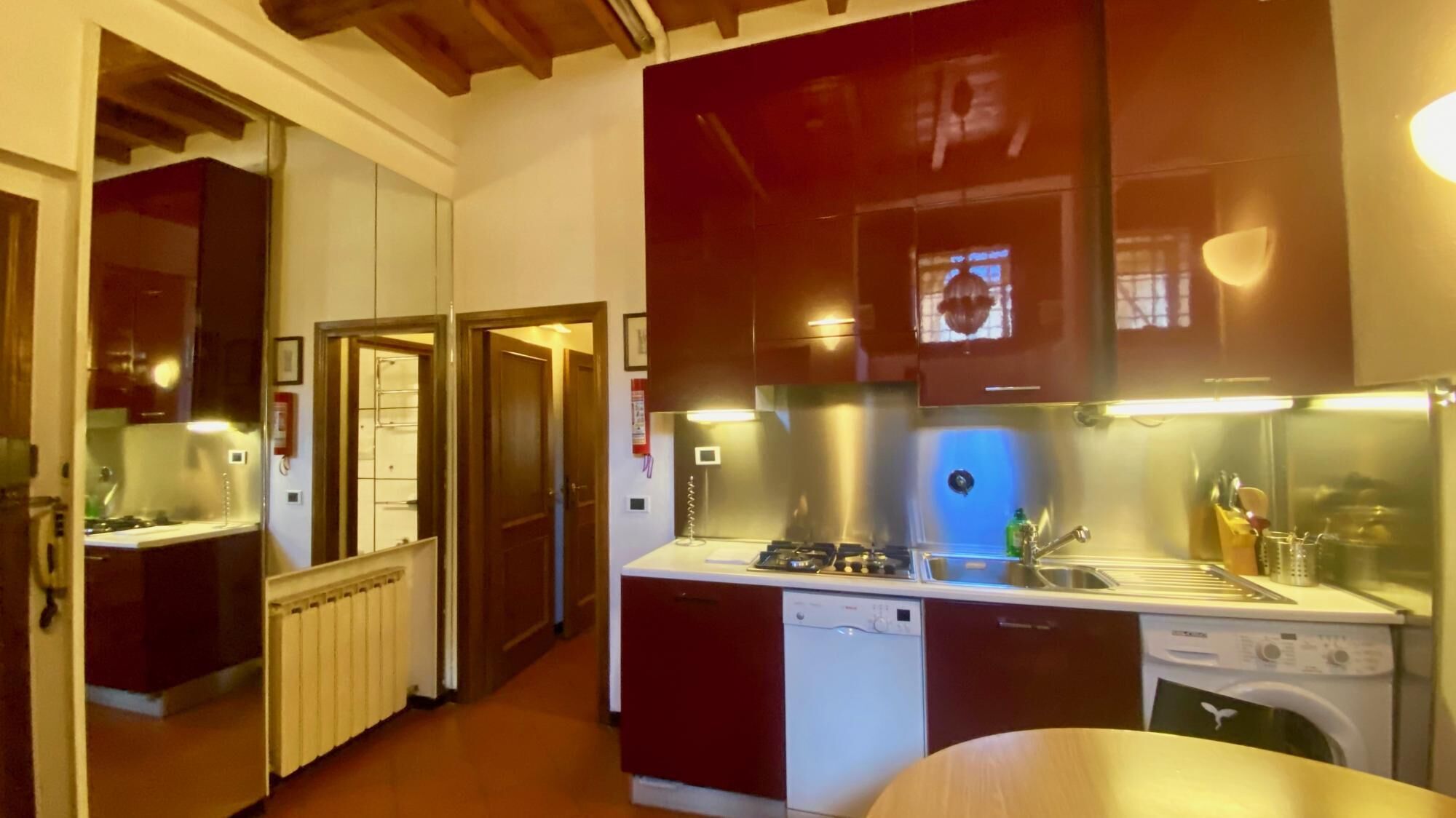 A compact kitchen with a gas stove, dishwasher, and a small sink.
