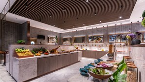 Una cocina moderna con una isla central, diferentes alimentos y un salpicadero de ladrillo.