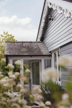A house with a covered porch, a garage door, and a small window.