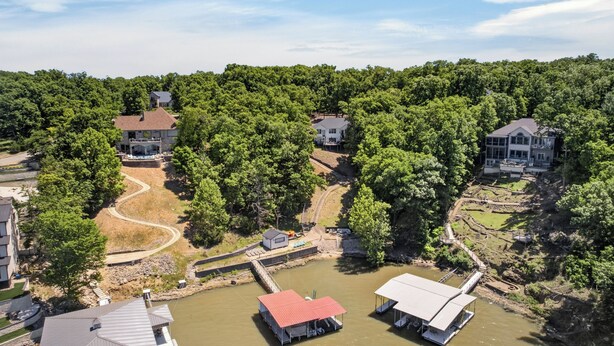 A residential area with houses, a dock, and a small water body. - Eagles Landing - Lakefront 5 Bdrm with Lakeside Tiki Bar (Sunrise Beach)