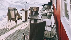 Une terrasse en bois avec des sièges extérieurs et une vue sur un paysage enneigé.