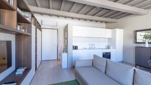 En moderne stue med sofa, sofabord og reol.