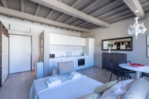 Une chambre d’hôtel moderne dotée d’un grand lit, d’une kitchenette, d’un coin repas et d’une salle de bain.