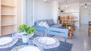 Un appartamento moderno con zona pranzo, divano e cucina.