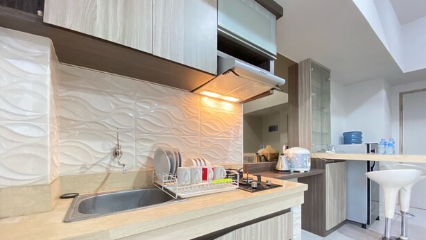 A modern kitchen with a built-in dishwasher, a sink, and a coffee machine. - Spacious And Homey 2Br Apartment At Newton Residence (Bandung)