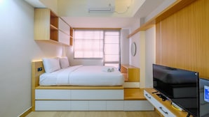 A compact bedroom with a bed, built-in TV, and storage cabinets. - Best Deal And Tidy Studio At Evenciio Margonda Apartment (Depok)