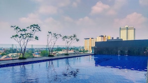 A rooftop swimming pool with a view of a cityscape. - Best Deal And Tidy Studio At Evenciio Margonda Apartment (Depok)
