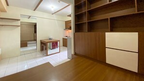 A modern kitchen with wooden cabinets, a built-in stove, and a dining area with a small table and chairs. - Japanese Style Spacious 1Br At Gateway Ahmad Yani Cicadas Bandung (Bandung)
