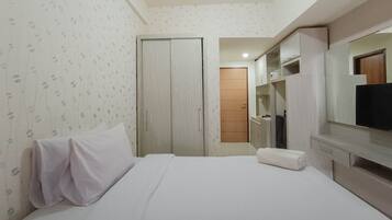 Une chambre d’hôtel avec un lit, une télévision et une armoire.