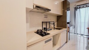 Une cuisine moderne équipée d’une cuisinière à gaz, d’un évier et d’appareils électroménagers en acier inoxydable.