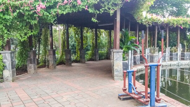 Un espace extérieur abrité, doté d’un chemin pavé, de piliers en pierre et d’équipements de musculation.