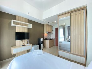 Relax in a spacious room with a large bed, flat-screen TV, and kitchenette area.
